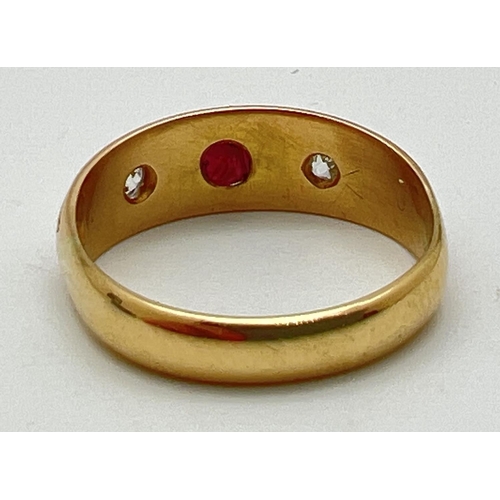 1012 - An 18ct gold gypsy style ring set with a central garnet and 2 diamonds. Stones set with claws and in... 