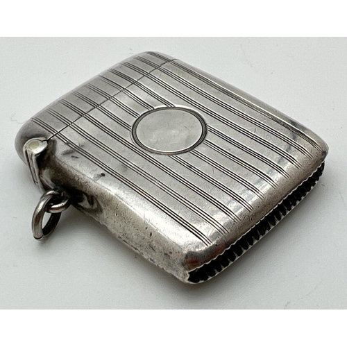 1123 - An art Deco silver vesta case with engine turned decoration and circular empty cartouche to front. S... 