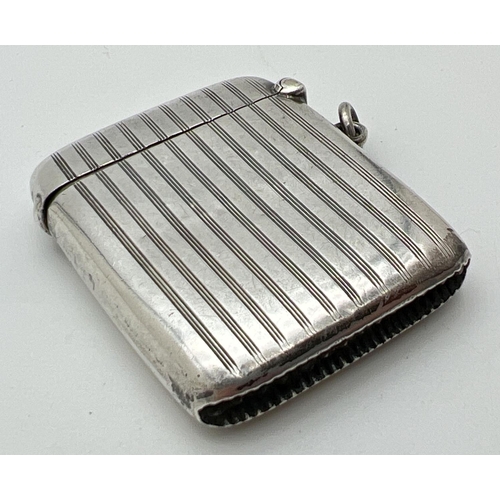 1123 - An art Deco silver vesta case with engine turned decoration and circular empty cartouche to front. S... 