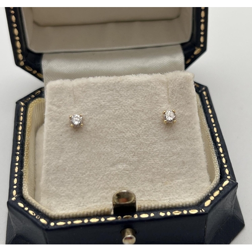 1040 - A pair of boxed 18ct gold & diamond stud earrings. Each earring holds a round cut 0.05ct diamond. To... 