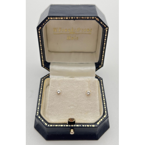 1040 - A pair of boxed 18ct gold & diamond stud earrings. Each earring holds a round cut 0.05ct diamond. To... 