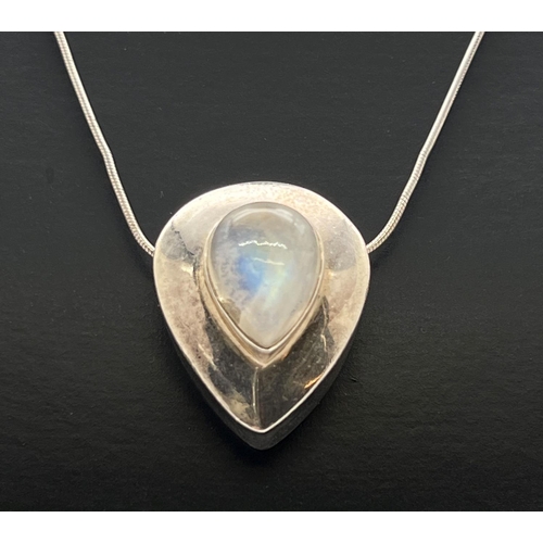 1041 - A modern design silver teardrop shaped pendant set with a moonstone cabochon. On a 22 inch snake cha... 