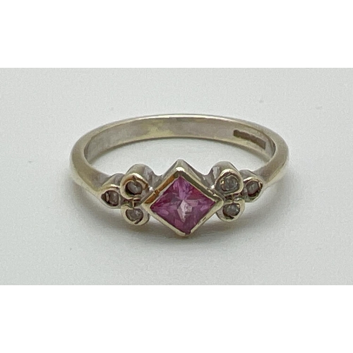 1054 - A 9ct gold pink sapphire and diamond dress ring. Central bezel set square cut pink sapphire with 3 b... 