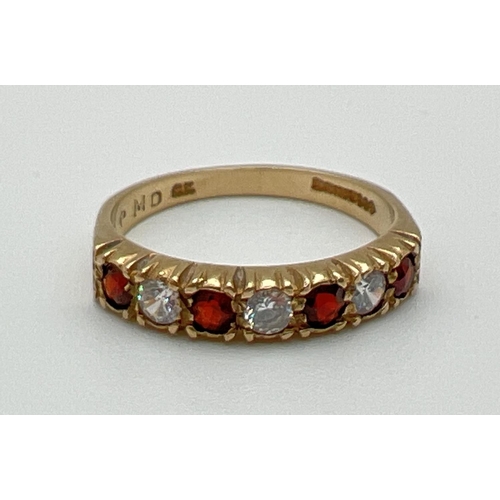 1055 - A vintage 9ct gold half eternity style ring set with alternating round cut garnets and cubic zirconi... 