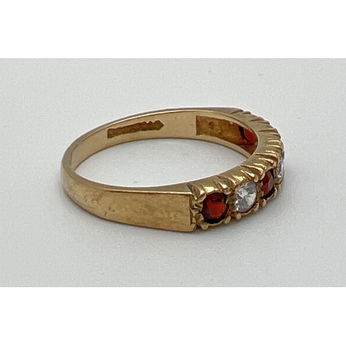 1055 - A vintage 9ct gold half eternity style ring set with alternating round cut garnets and cubic zirconi... 