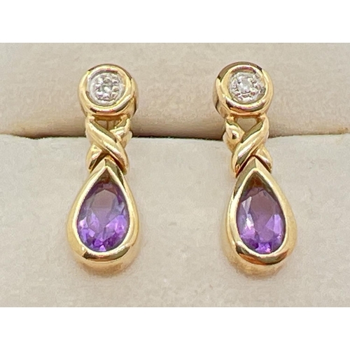 1002 - A pair of modern design 9ct gold amethyst and diamond set drop style earrings. Each set with a small... 