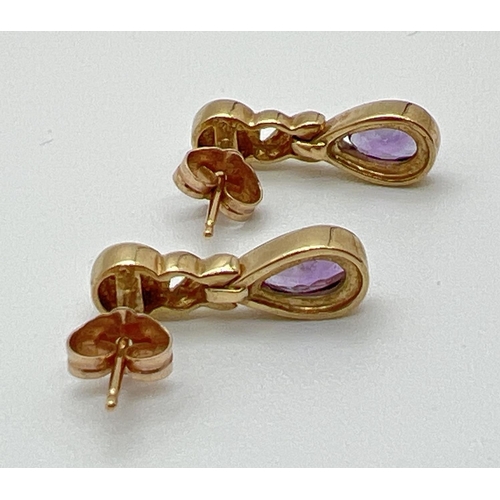 1002 - A pair of modern design 9ct gold amethyst and diamond set drop style earrings. Each set with a small... 