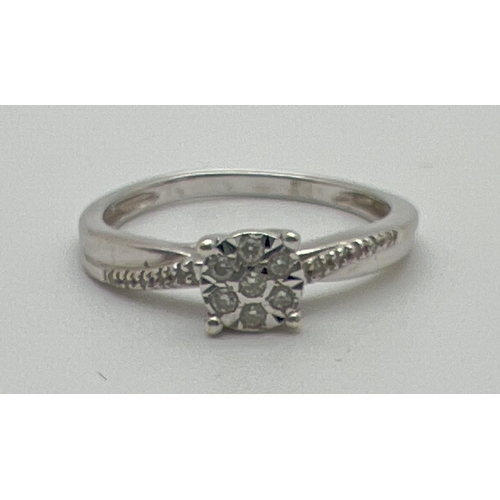 1060 - A 9ct white gold modern design illusion set diamond dress ring. Total diamond .10ct. Centre of ring ... 