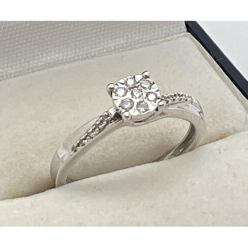 1060 - A 9ct white gold modern design illusion set diamond dress ring. Total diamond .10ct. Centre of ring ... 