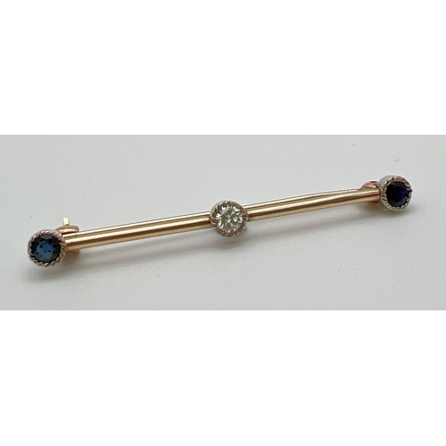 1003 - A vintage design 9ct gold bar brooch set with 2 round cut sapphires and a round cut diamond. Each st... 