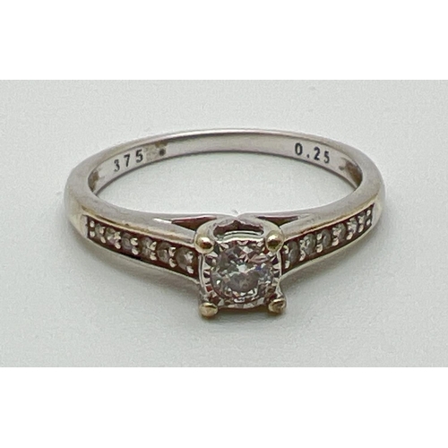 1067 - A 9ct white gold .25ct diamond dress ring. Central round cut diamond with 6 graduating small round c... 