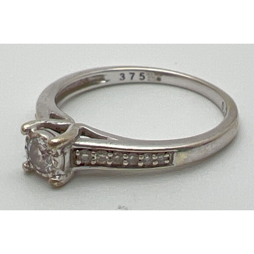 1067 - A 9ct white gold .25ct diamond dress ring. Central round cut diamond with 6 graduating small round c... 