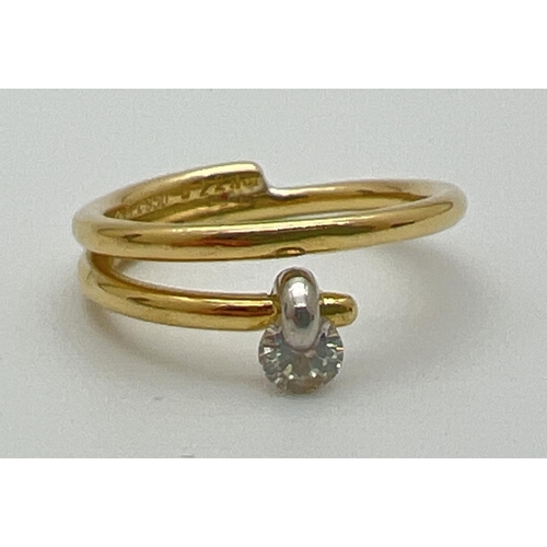 1073 - A contemporary design 18ct gold and platinum dress ring with tension set 0.20ct diamond. Makers name... 