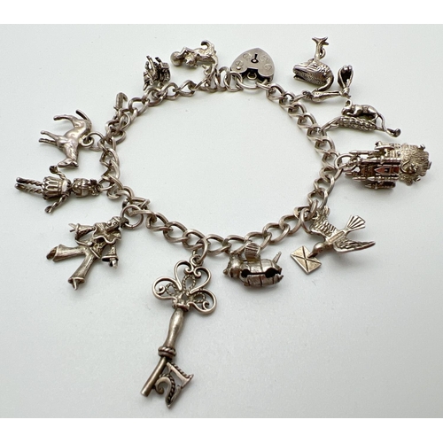 1006 - A vintage silver charm bracelet with padlock clasp and 12 charms. Charms include: a castle, bumble b... 