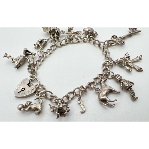 1006 - A vintage silver charm bracelet with padlock clasp and 12 charms. Charms include: a castle, bumble b... 