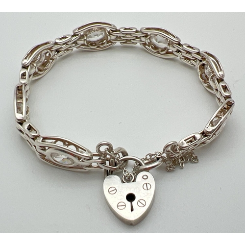 1091 - A decorative stone set link bracelet with padlock clasp and safety chain. Makers mark and 925 stampe... 