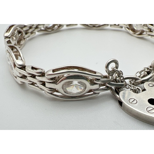 1091 - A decorative stone set link bracelet with padlock clasp and safety chain. Makers mark and 925 stampe... 