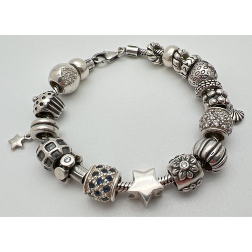 1093 - A Lovelinks style silver charm bracelet with lobster style clasp and 18 charms/beads. Beads include ... 