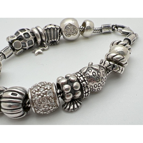 1093 - A Lovelinks style silver charm bracelet with lobster style clasp and 18 charms/beads. Beads include ... 