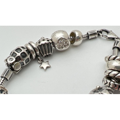 1093 - A Lovelinks style silver charm bracelet with lobster style clasp and 18 charms/beads. Beads include ... 