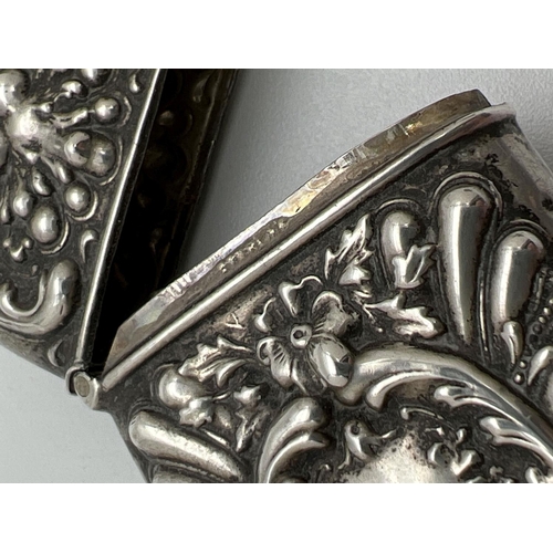 1132 - A Victorian silver vesta case with decorative floral and scroll detail shown in relief. Hinged lid, ... 