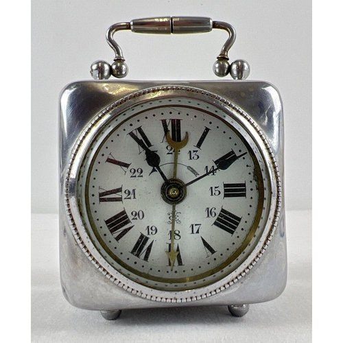 1162 - An antique wind up bedside alarm clock with enamelled face and bevel edged glass. A small silver pla... 