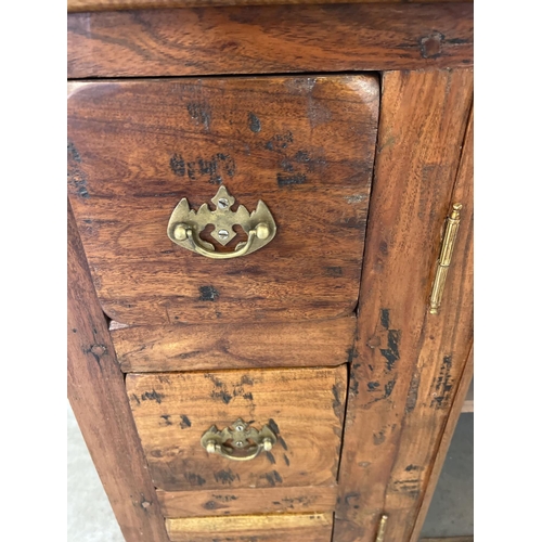 1295 - A heavy Indian rubber wood sideboard with 2 central glass panelled doors & 6 small drawers. Central ... 