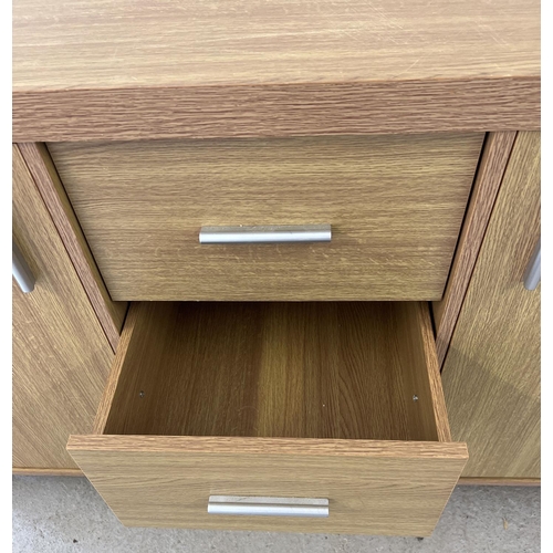 1296 - A modern light wood effect, sideboard with 2 cupboards and 3 central drawers. Long silver coloured h... 