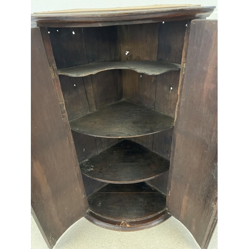 1300 - A Georgian mahogany curve fronted corner cupboard with oak interior shelves (top shelf shaped). Appr... 