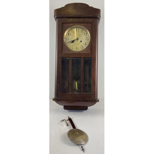 1164 - A vintage dark oak cased wall hanging, swinging pendulum clock. Complete with key & pendulum. With m... 