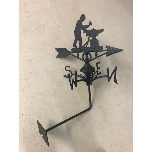 1141 - A black cast metal weather vane with blacksmith detail to top. Complete with wall fixing bracket and... 