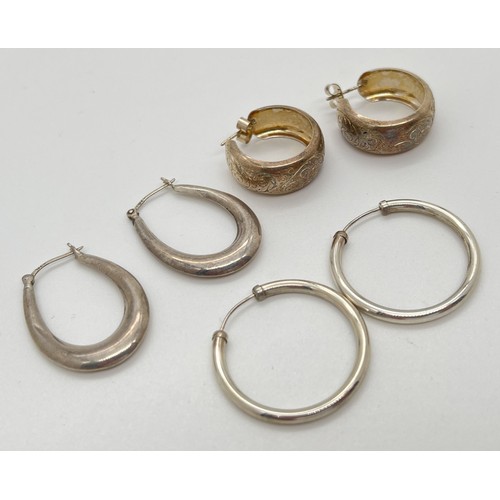 1101 - 3 pairs of silver hooped earrings. A pair of oval shaped hoops with hinged posts stamped 925; a pair... 