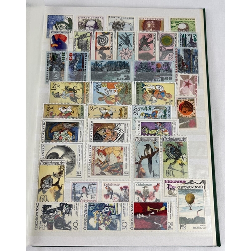 126 - A green vintage stamp album containing a collection of unused world stamps together with loose sheet... 