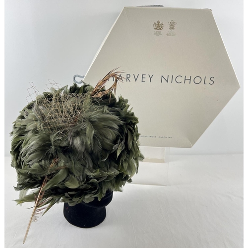 1323 - A green feather fascinator style hat with pheasant feather and net detail. Together with a Harvey Ni... 