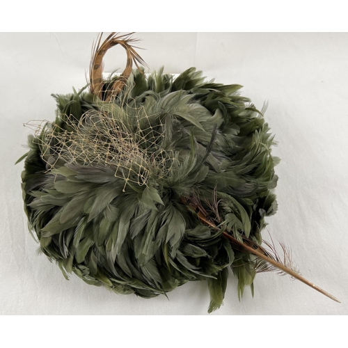 1323 - A green feather fascinator style hat with pheasant feather and net detail. Together with a Harvey Ni... 