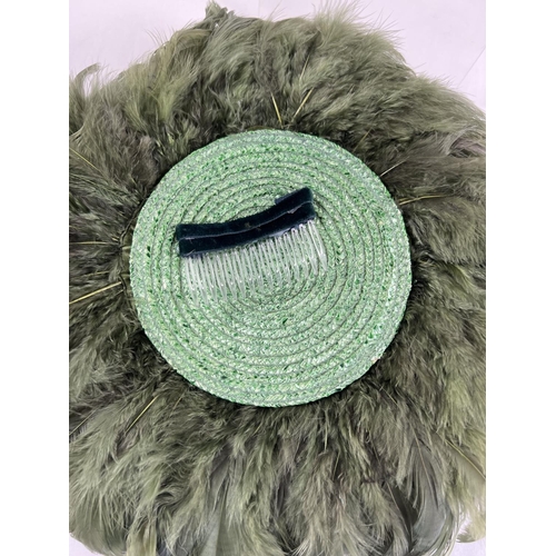 1323 - A green feather fascinator style hat with pheasant feather and net detail. Together with a Harvey Ni... 