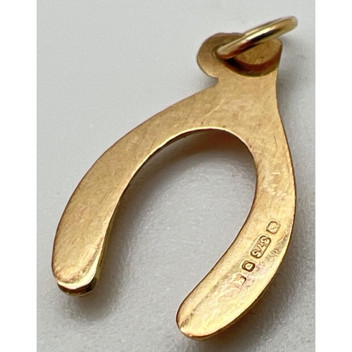 1007 - A 9ct gold wishbone charm/pendant. Full hallmarks to back. Approx. 0.4g. 2cm long including bale.