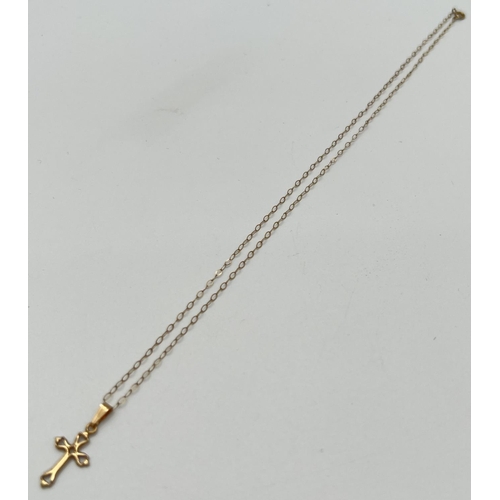 1018 - A delicate 9ct gold cross pendant with openwork detail. On a 15 inch fine belcher chain with spring ... 