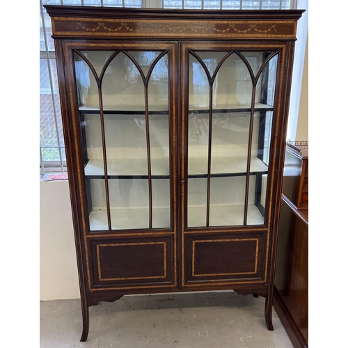 1344 - An Edwardian inlaid display cabinet with double doors and fabric lined interior shelving and back. W... 