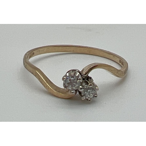 1039 - A vintage 9ct gold double diamond twist design dress ring. Two single 0.07 carat diamonds in a verti... 