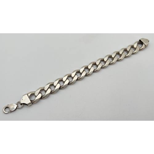 1045 - A heavy silver 9 inch large curb link bracelet with lobster clasp. Silver marks to fixings and clasp... 