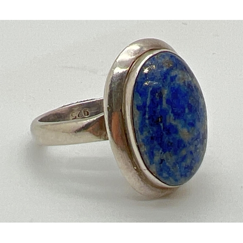 1062 - A modern design silver dress ring set with a oval cut cabochon of Lapis Lazuli. 925 stamped to insid... 