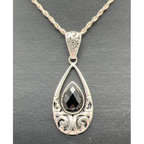 1067 - A modern design drop pendant with pierced work and faceted teardrop onyx stone. On an 18 inch twiste... 