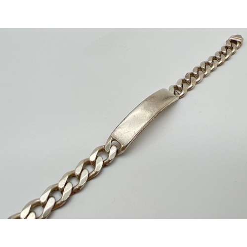 1071 - A heavy silver curb chain identity bracelet with empty cartouche. Approx 8.5 inches long. Total weig... 