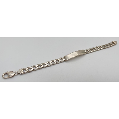 1071 - A heavy silver curb chain identity bracelet with empty cartouche. Approx 8.5 inches long. Total weig... 