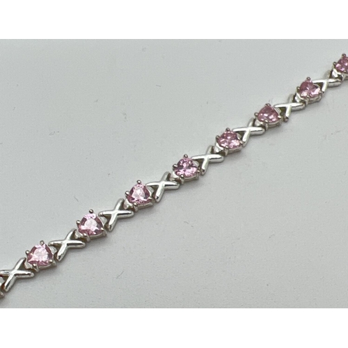 1073 - A modern design silver Hearts & Kisses bracelet set with 19 heart cut pale pink stones. Push clasp w... 