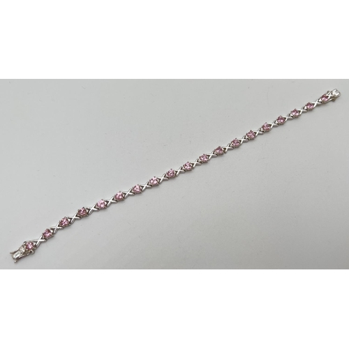 1073 - A modern design silver Hearts & Kisses bracelet set with 19 heart cut pale pink stones. Push clasp w... 