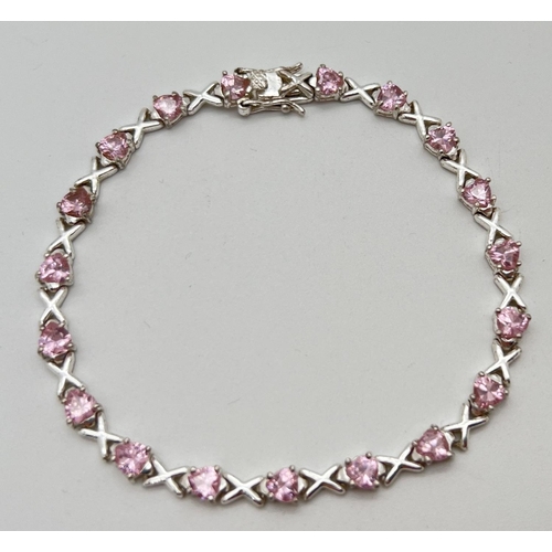 1073 - A modern design silver Hearts & Kisses bracelet set with 19 heart cut pale pink stones. Push clasp w... 