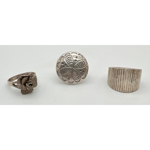 1077 - 3 vintage silver dress rings. A band style with ridged detail, a rose head ring and a circular head ... 