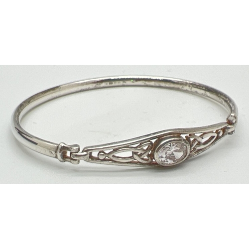 1084 - A silver Celtic design bangle set with a central oval cut clear quartz stone. Marked 925 to inside. ... 